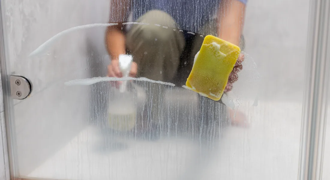 Frameless clear glass shower door in a clean bathroom